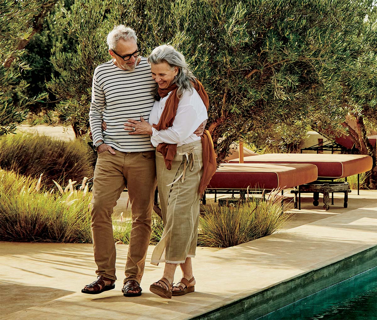 Happy elderly couple walking by a pool